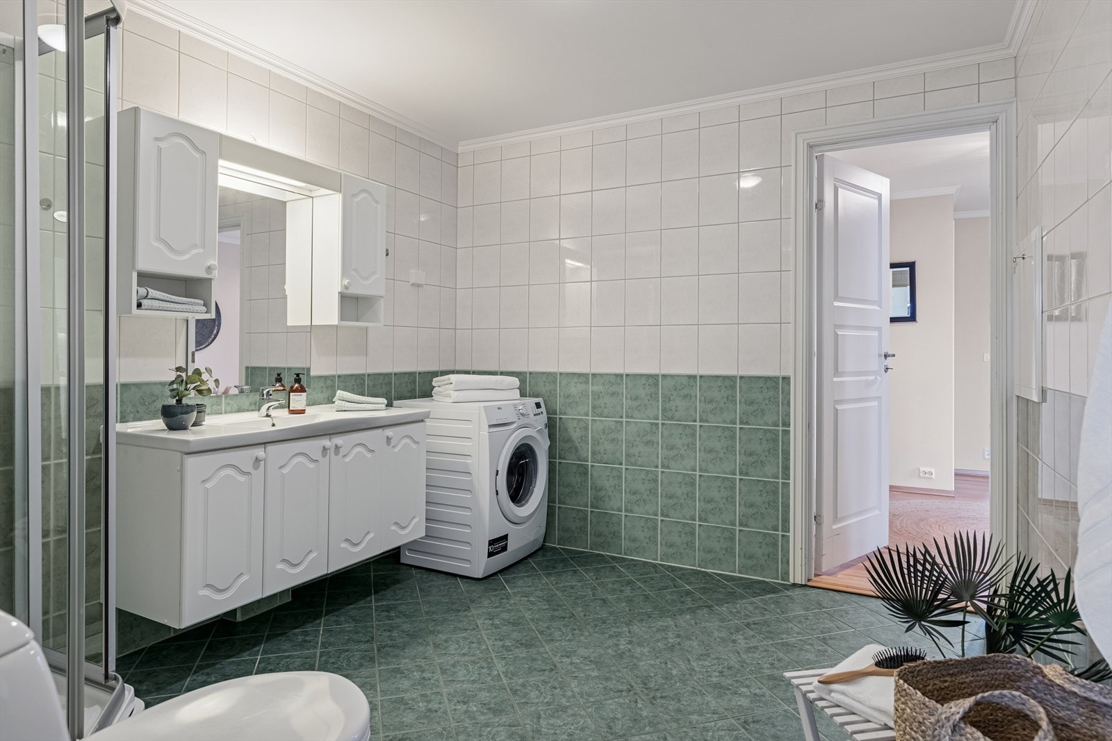 Badet har eldre standard og inneholder det du trenger: Dusjkabinett, toalett, opplegg til vaskemaskin og servant med innredning. Galleribilde