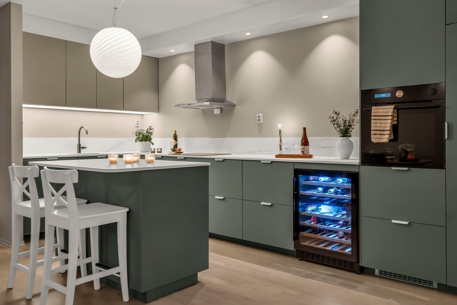 Benkeplate og kant langs veggen i keramikk fra Nerostein. Dette er et materiale som er enkelt å holde rent og som tåler varme. Galleribilde