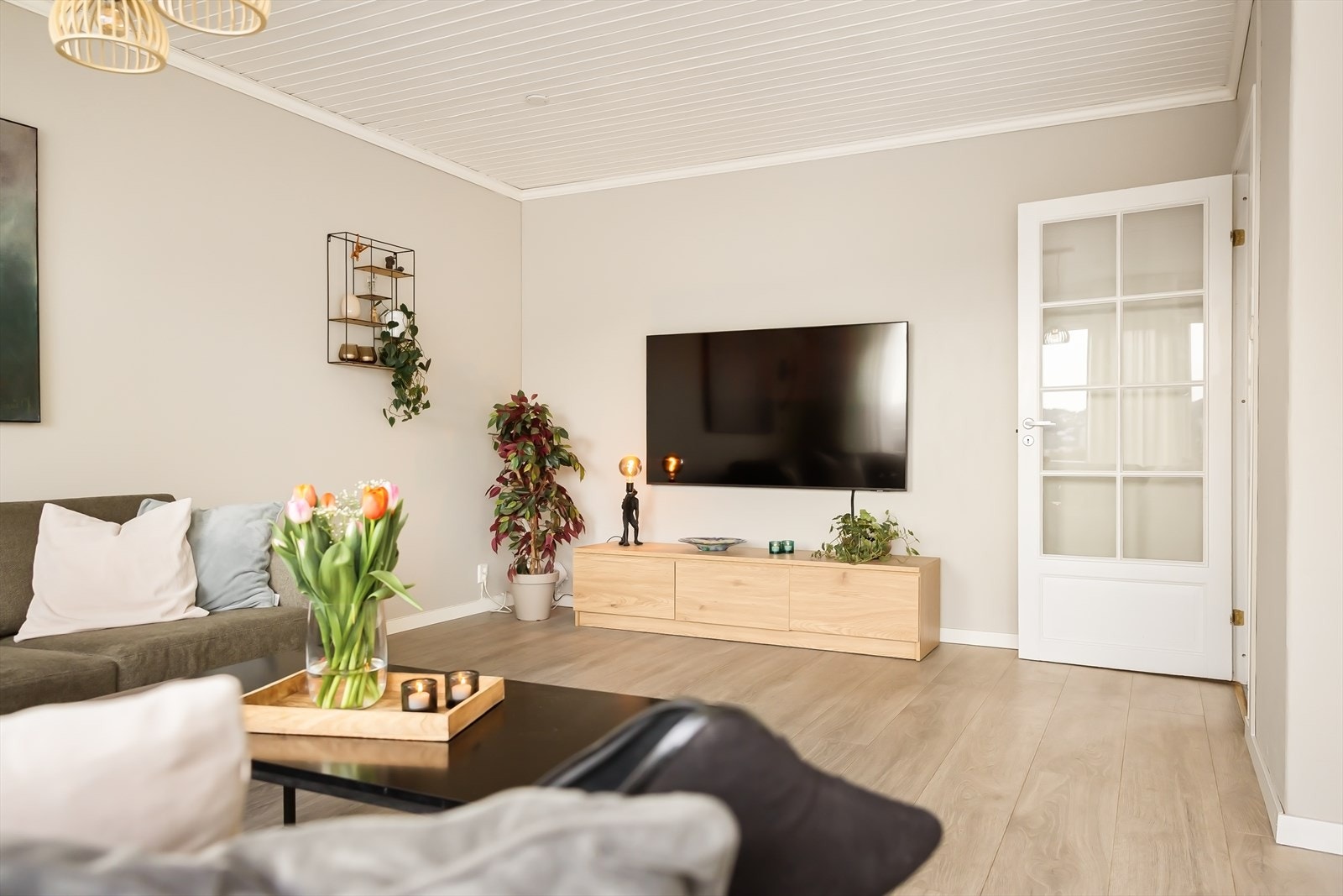 Stuen har god plass til både tv-løsning og møblement, og veggen bak tv går direkte inn mot kjøkkenet. Kanskje man kan slå ned veggen på sikt og lage åpen løsning? Galleribilde