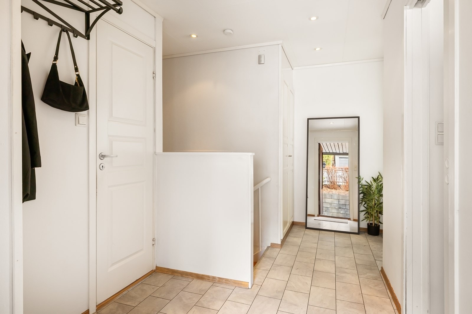 Romslig entré med plass til å henge fra seg yttertøy og sko, døren til venstre leder inn til et wc. Galleribilde