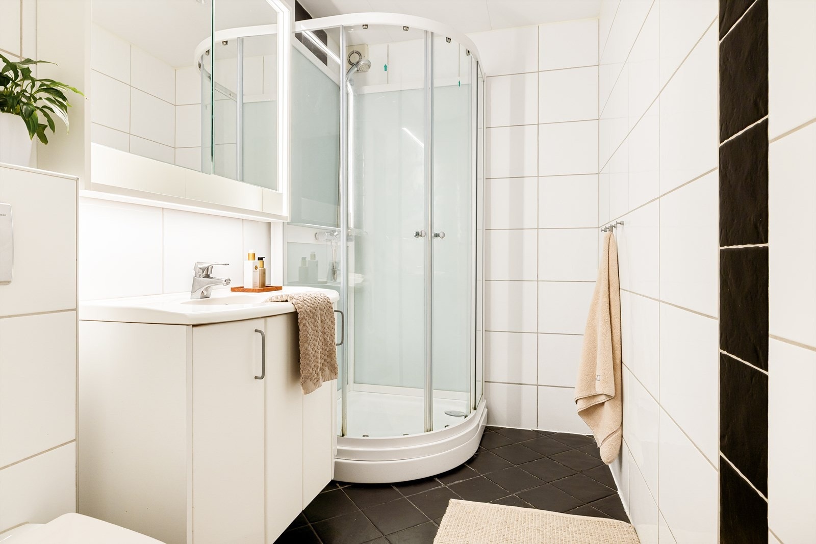 Helfliset bad fra 2007 med varmekabler i gulv, vegghengt wc, servant med oppbevaring og dusjkabinett. Galleribilde