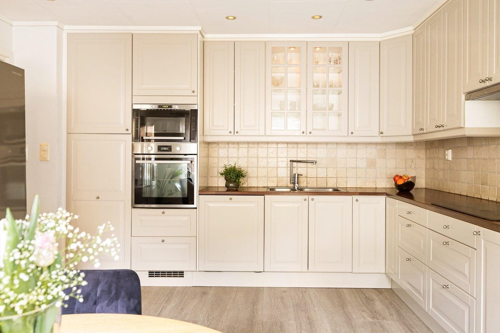 Kjøkkenet er pent med lyse profilerte fronter, benkeplate i laminat og integrete hvitevarer med unntak av kjøleskap. Galleribilde