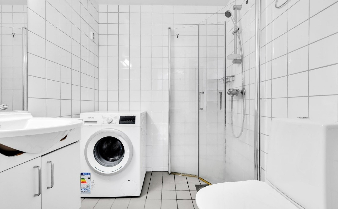 Flislagt bad med opplegg for vaskemaskin. Galleribilde