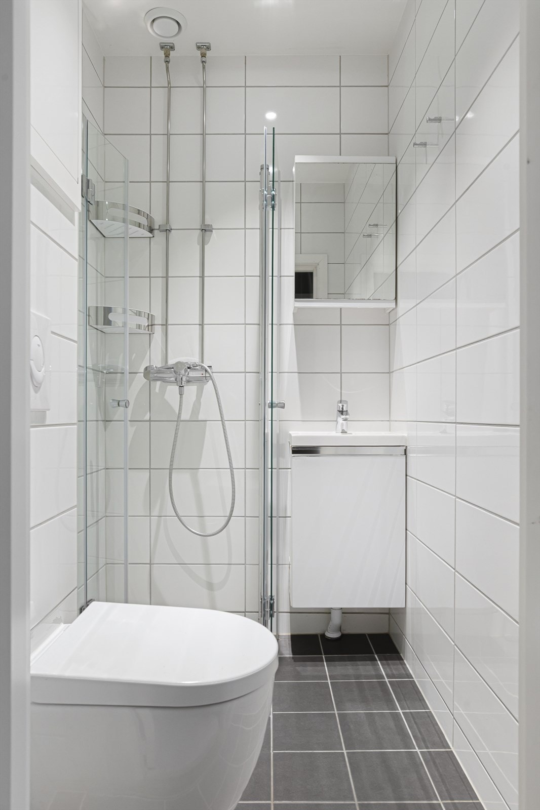 Pent, flislagt bad oppgitt renovert i 2024. Varmekabler i gulv, spotter i tak og naturlig ventilasjon. Badet har dusj, servant og WC. Galleribilde