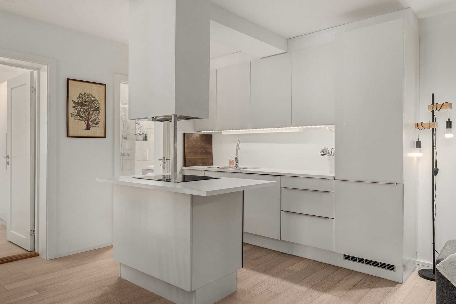 Kjøkken i moderne stil med lys innredning og slette fronter Galleribilde