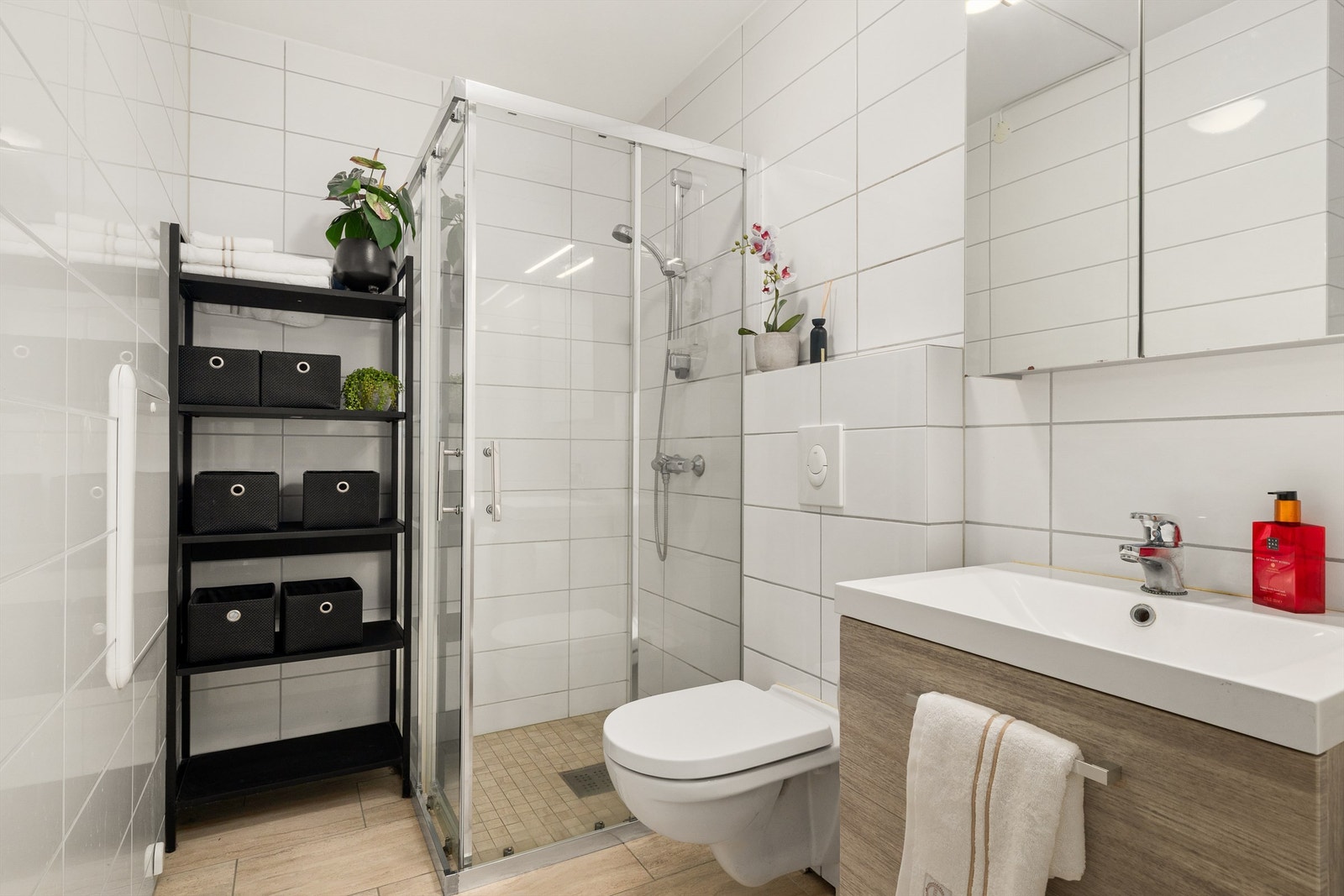 Dusjnisje, servant i innredning med overspeil og vegghengt toalett Galleribilde