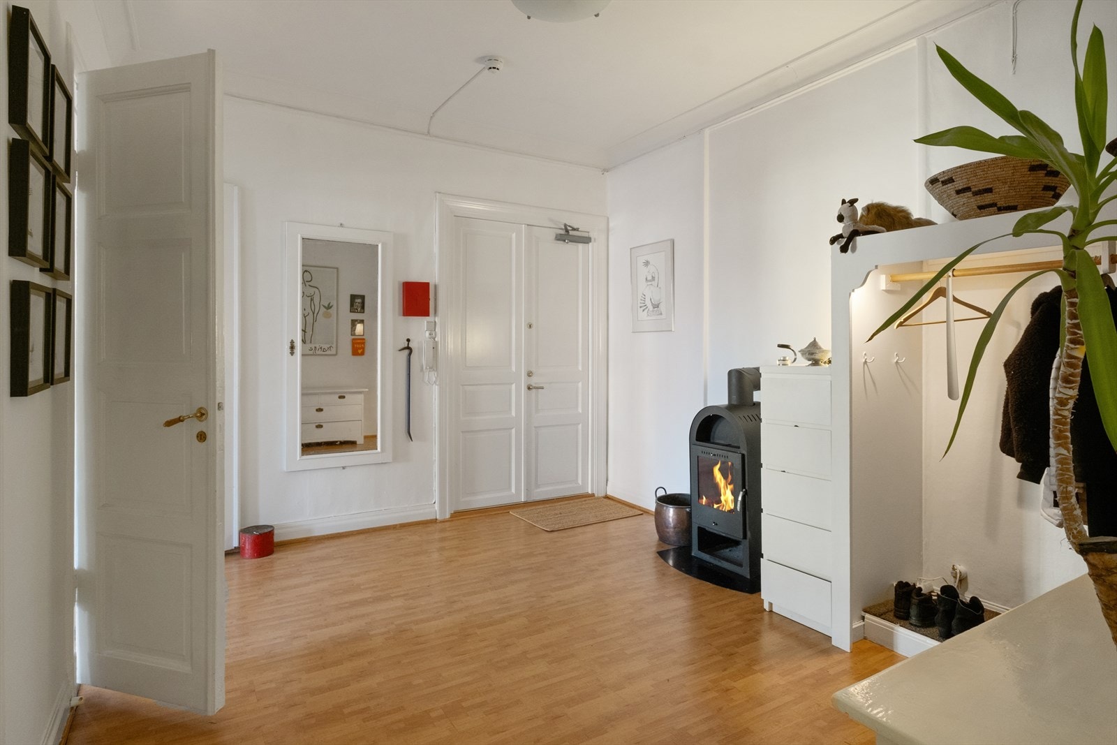 Leiligheten har en romslig entré med god plass til yttertøy og sko. I entréen er det en peisovn og installert dørcalling. Galleribilde