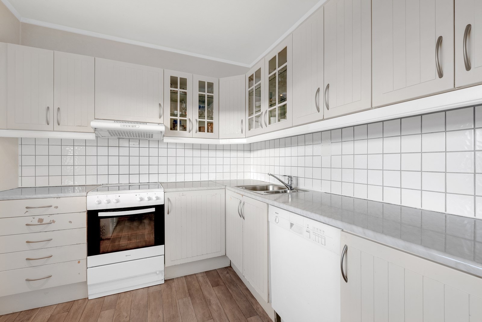 Innredningen har profilerte fronter, laminatbenkeplate med fliser over og opplegg for oppvaskmaskin. Galleribilde