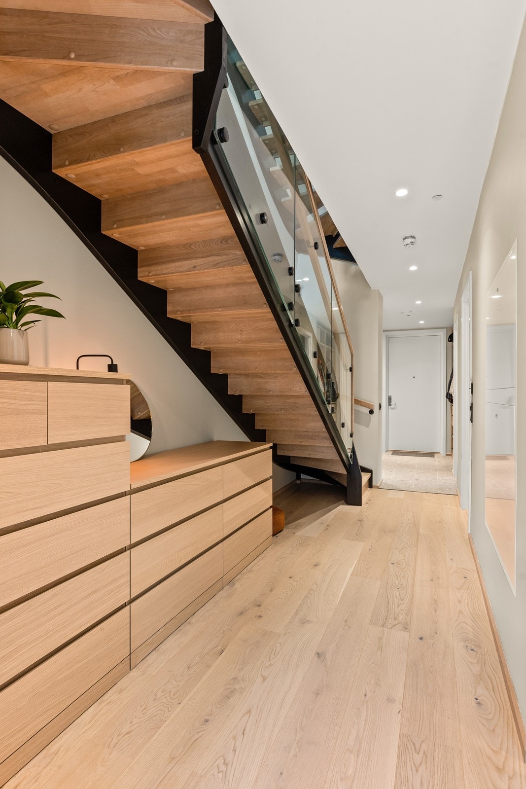 Moderne åpen trappeløsning med trinn i heltre, stålvanger og glassrekkverk. Galleribilde