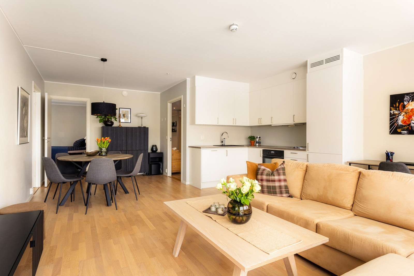 Den åpne løsningen mot kjøkkenet skaper en sosial og luftig atmosfære, hvor det er enkelt å samle familie og venner. Galleribilde