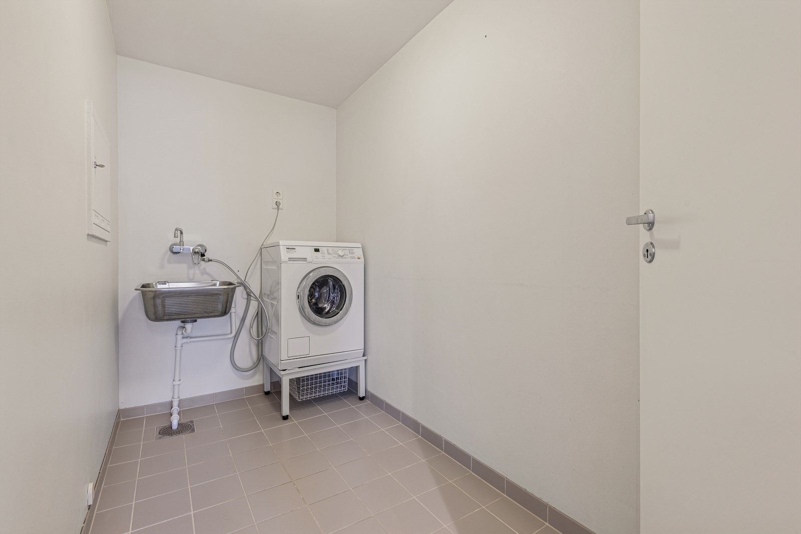 Vaskerommet er innredet med opplegg for vaskemaskin, vegghengt utslagsvask og varmtvannsbereder. Galleribilde