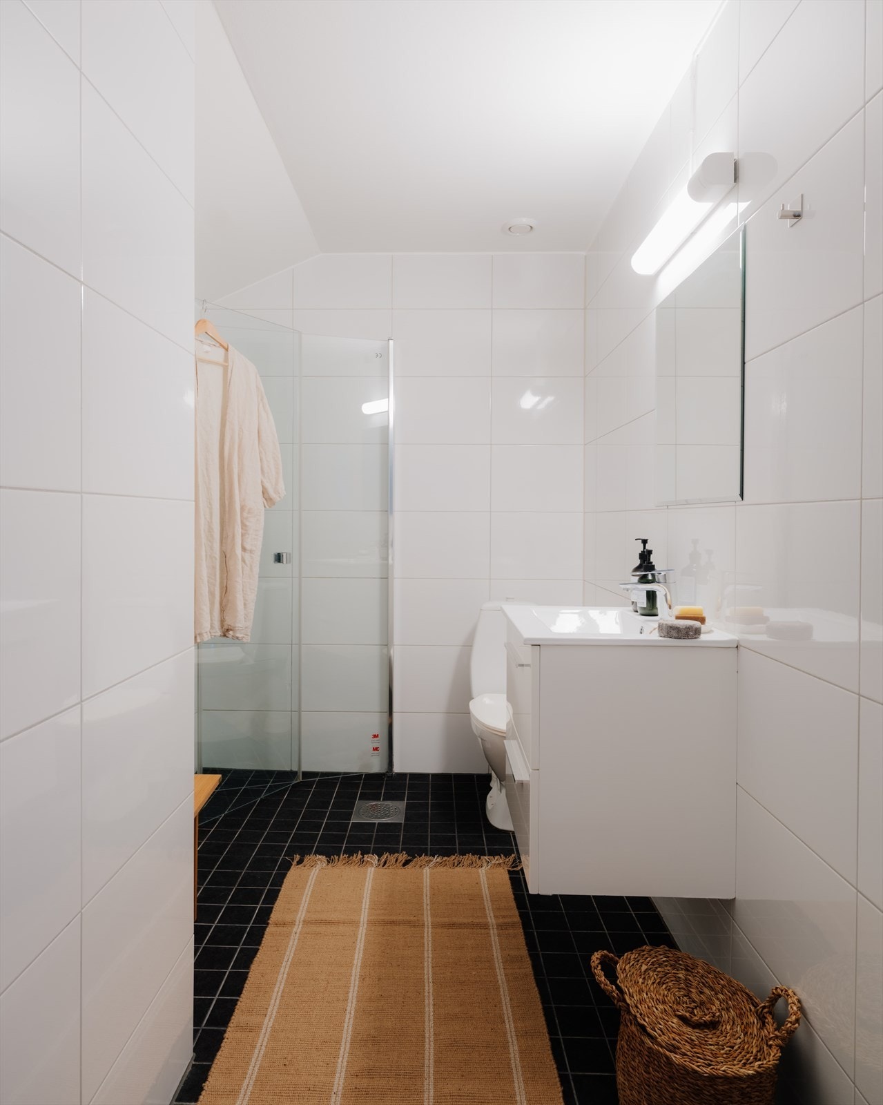 Badet er innredet med toalett, dusjhjørne og servant på underliggende servantskap. Galleribilde