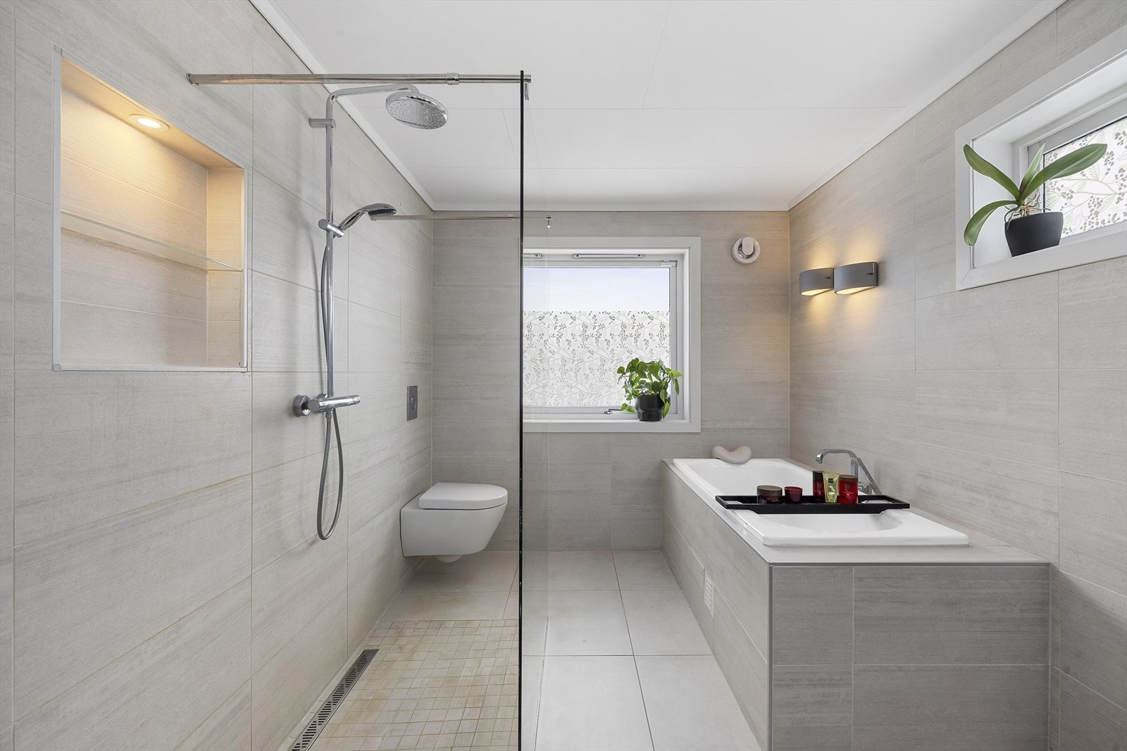 Baderommet har romslig dusjnisje med glassvegg og innmurt badekar Galleribilde