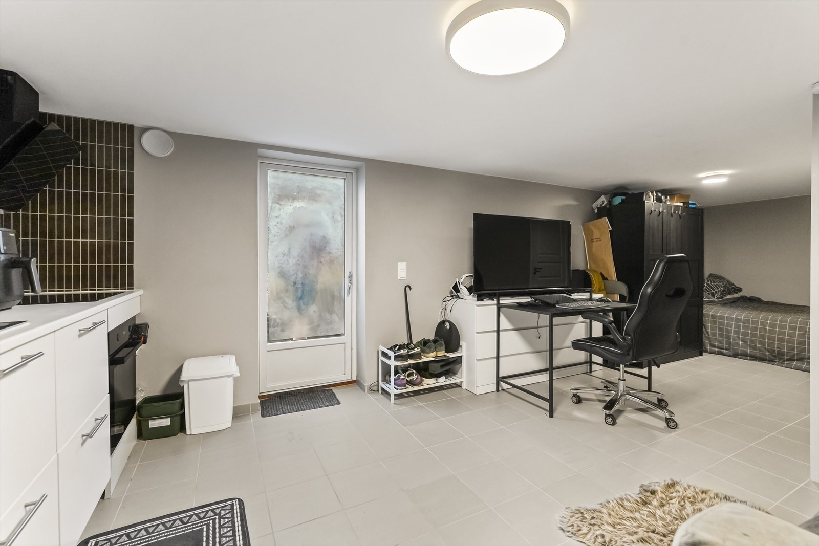 Hybel i kjelleretasjen er innredet med åpen stue- og kjøkkenløsning samt eget bad. Gulv har flis og veggoverflater er malt i tidsriktige fargevalg. Galleribilde