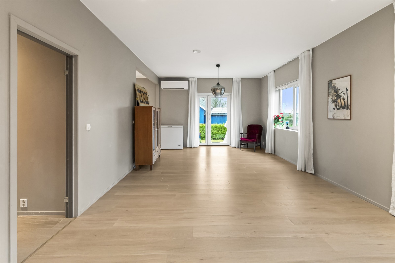 Lys og romslig stue med laminat på gulv. Galleribilde