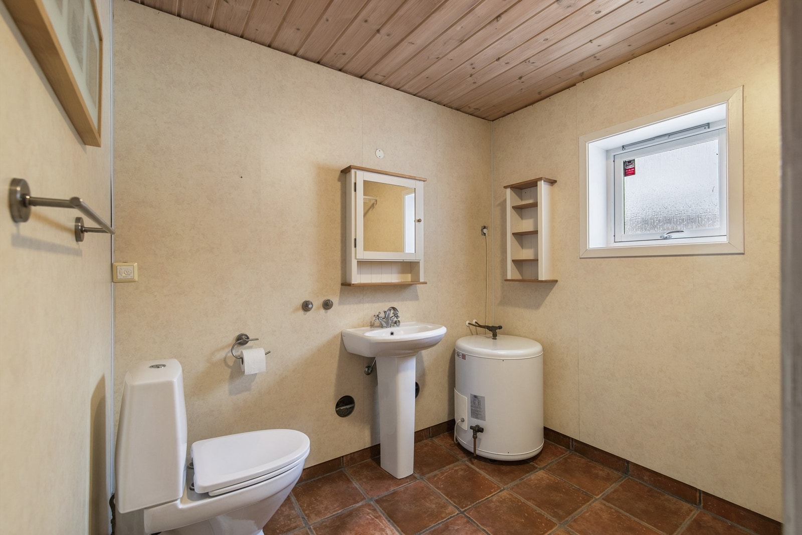 Badet i gjestehuset er fra byggeåret. Gulv er flislagt og det er montert våtromsplater på vegger. Himling med panel. Gulvstående søyleservant, dusjnisje og gulvstående toalett er montert. Samt opplegg for vaskemaskin. Galleribilde