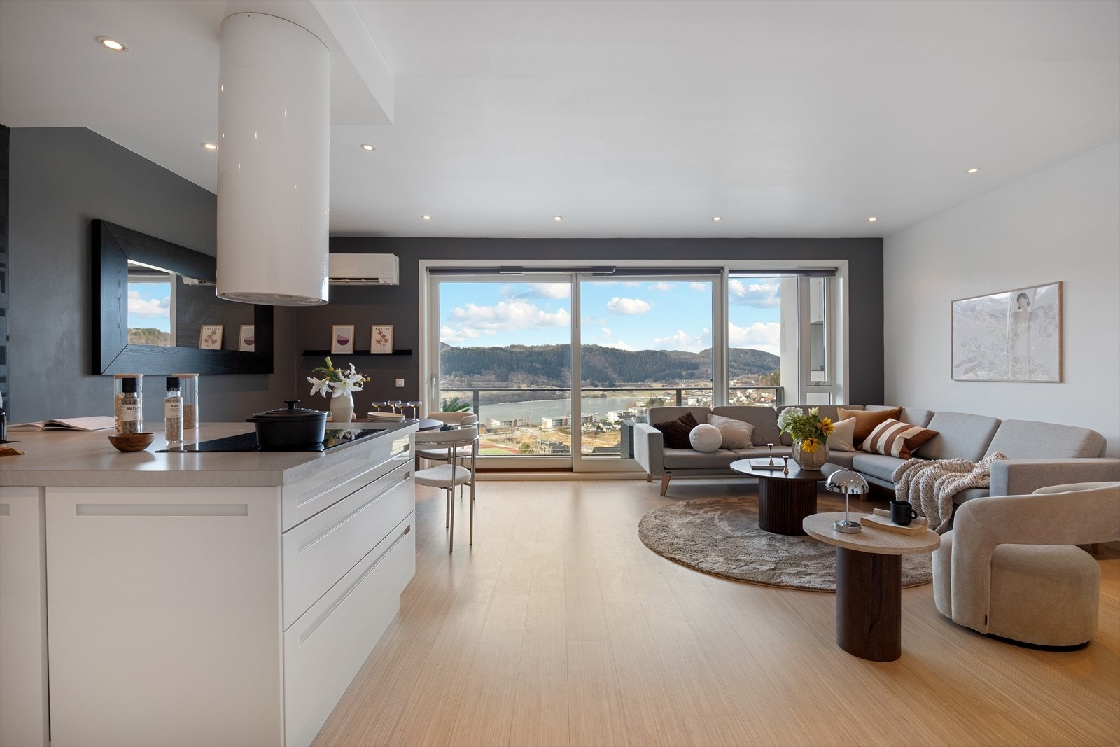 Kjøkkenet er stilrent med glatte fronter og praktiske arbeidsflater. Galleribilde