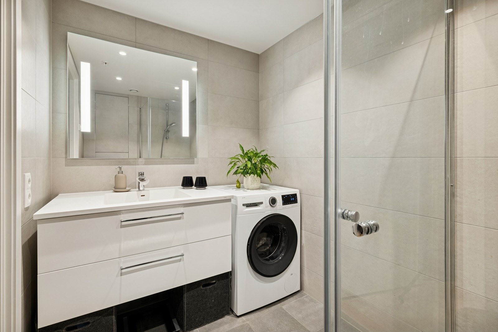 Baderomsinnredning med heldekkende servant og speil med integrert belysning. Galleribilde