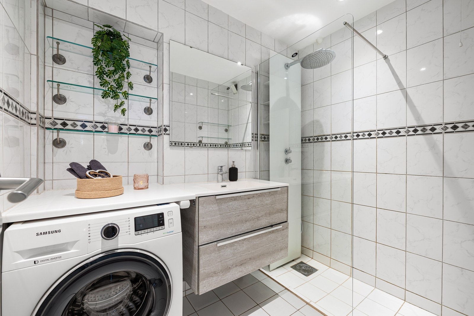 Lyst, flislagt bad med praktisk innredning og god benkeplass. Opplegg for vaskemaskin. Galleribilde