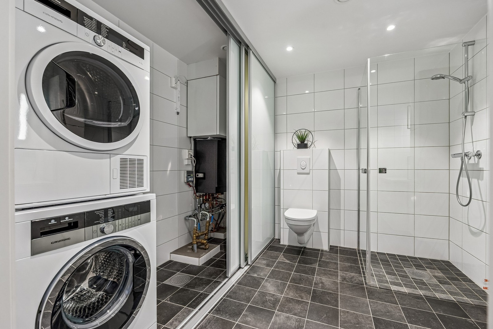 Servant i servantskap, veggmontert wc og opplegg for vaskemaskin - smart og funksjonell løsning. Galleribilde