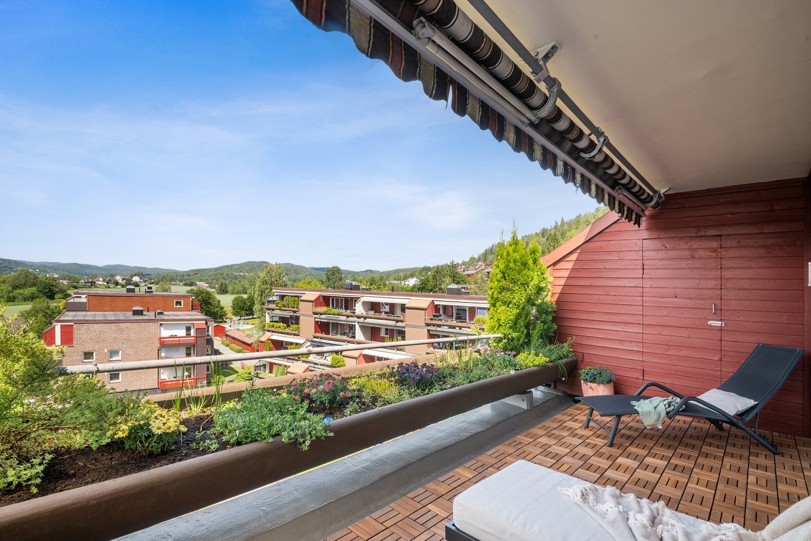 Herlig veranda som har treheller og blomsterkasser i betong. Galleribilde