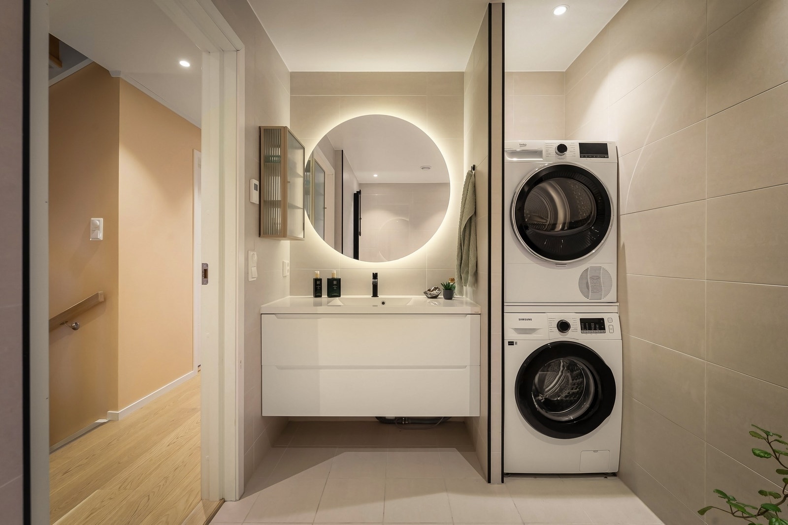 Lekkert flislagt baderom med opplegg for vaskemaskin/tørketrommel Galleribilde