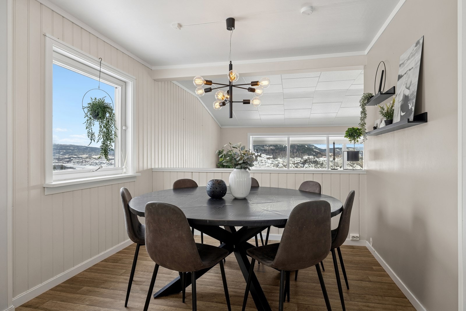 Store vinduer gir godt med dagslys og fremhever den flotte utsikten. Kjøkkenet har direkte tilknytning til en romslig spisestue. En del av veggen mot stuen er åpnet opp for bedre lys, utsikt og en sømløs overgang mellom rommene. Galleribilde