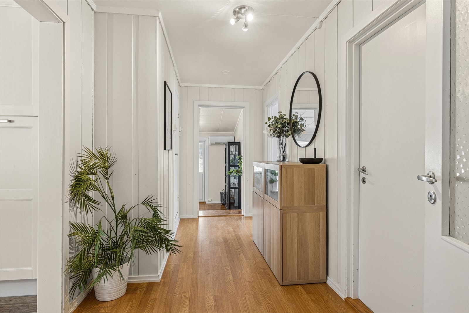 Mellomgangen leder deg sømløst videre inn mot stuen og fungerer som et naturlig bindeledd mellom boligens ulike oppholdsrom. Galleribilde