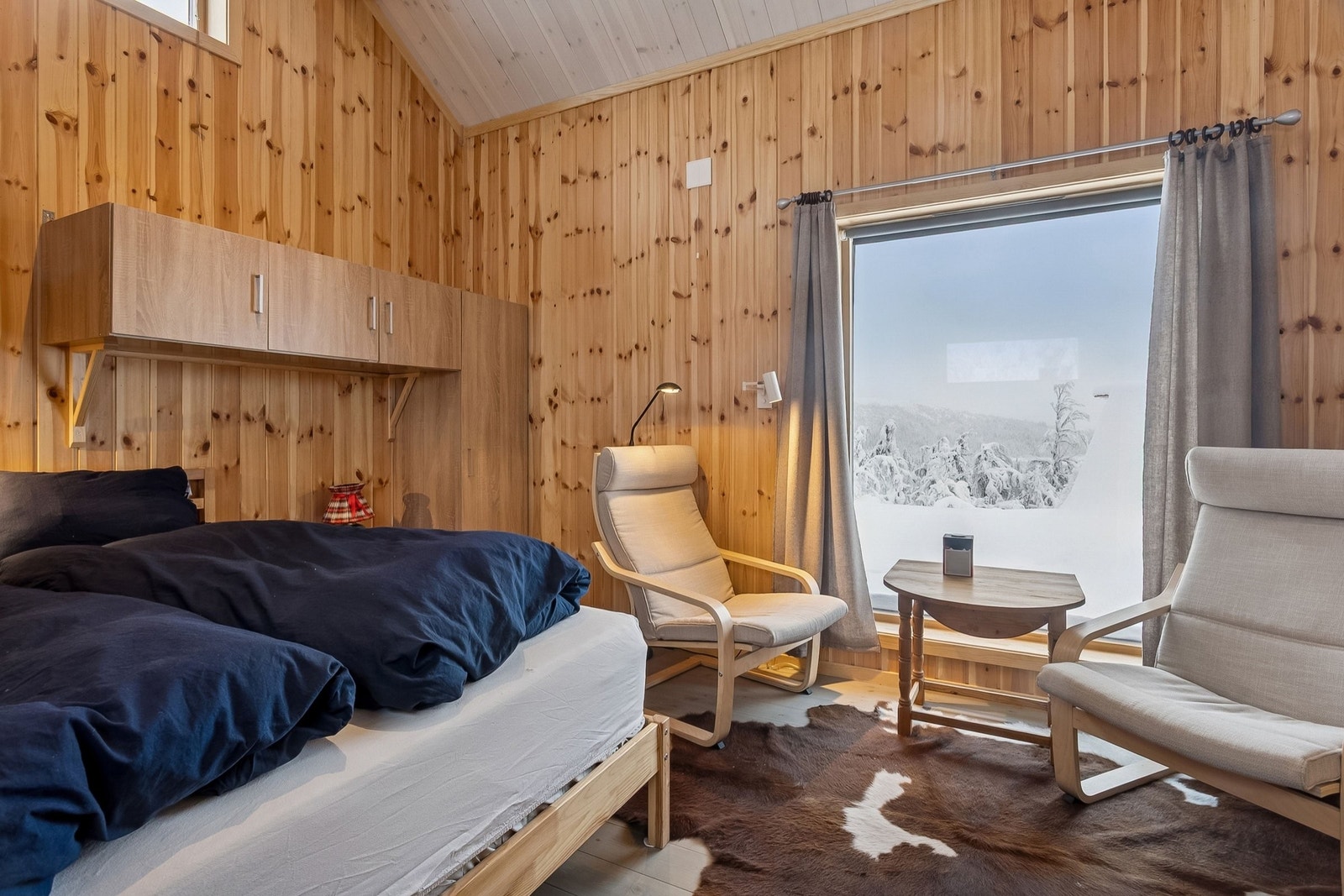 Sove-/oppholdsrom i tillbygget med plass til dobbeltseng, skap og sittegruppe. Galleribilde