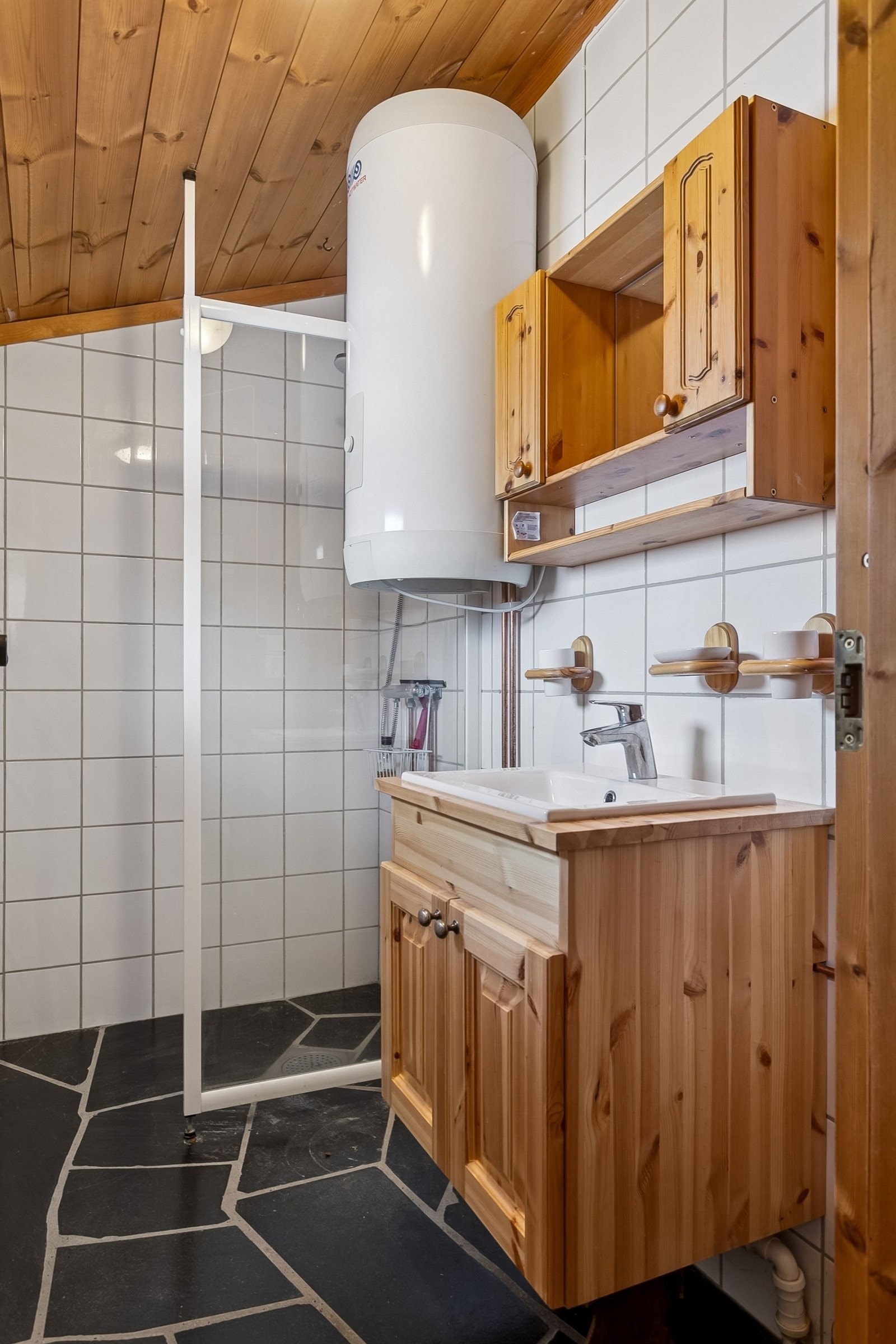 Hovedhytta har adskilt toalett og bad. Badet har flislagte vegger, oppdalsskifer på gulv med varmekabler, stor varmtvannsbereder, dusj med sluk og vask nedfelt i toalettskap. Galleribilde