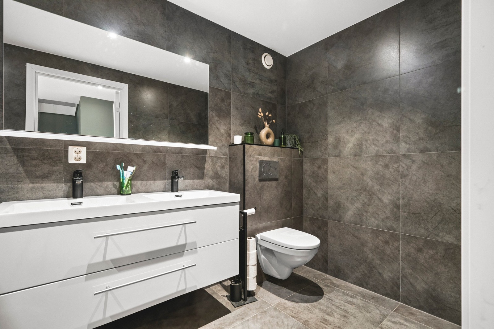 Badet måler 5,9 kvm og er helfliset med varmekabler i gulvet. Galleribilde