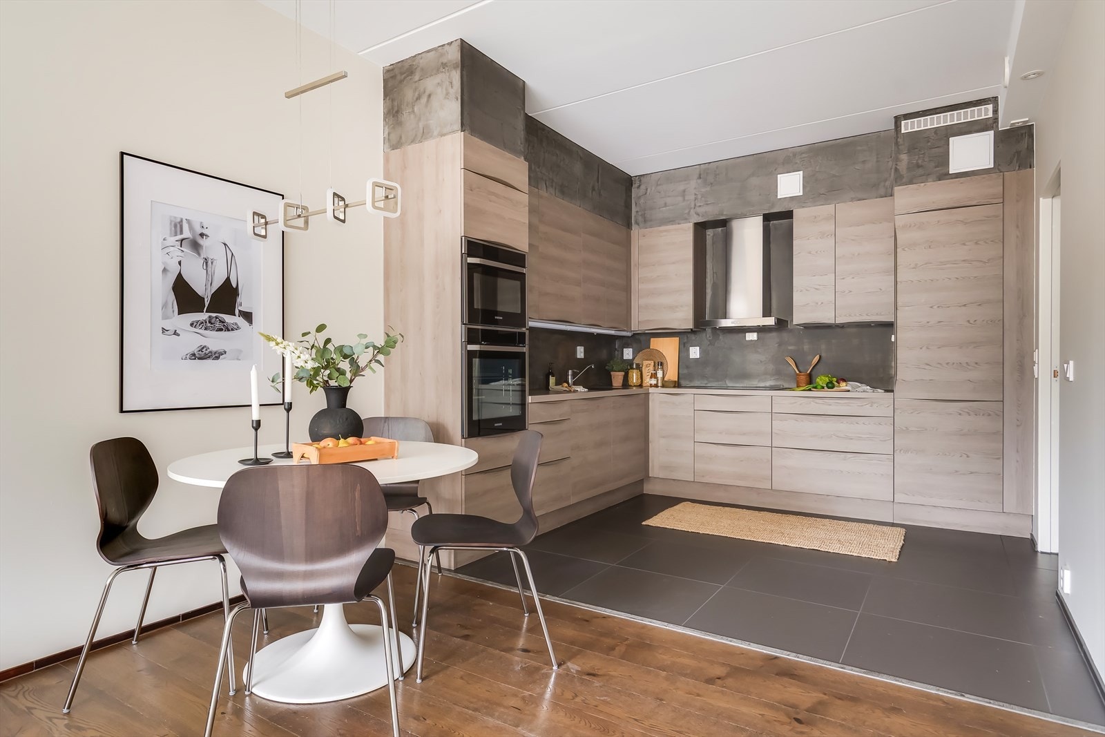 Pent kjøkken innredet med slette fronter og benkeplate i laminat Galleribilde