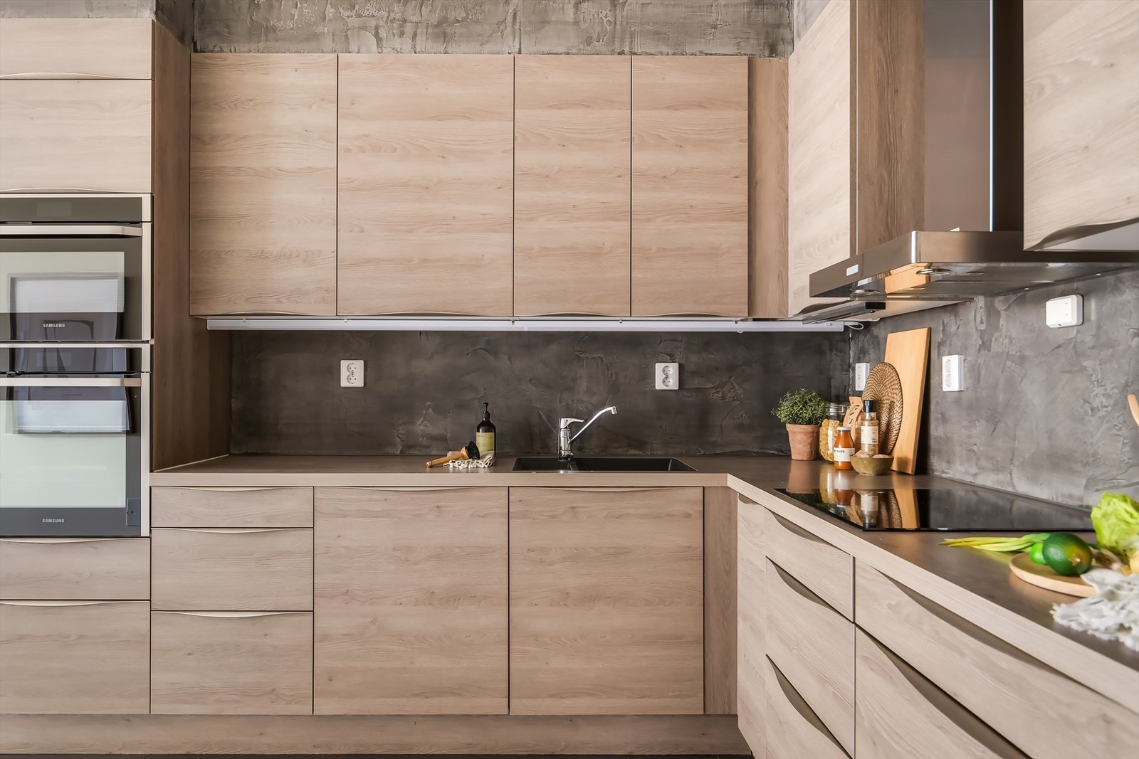 Kjøkkenet er utstyrt med integrerte hvitevarer som kjøle- og fryseskap, oppvaskmaskin, stekeovn og mikro Galleribilde