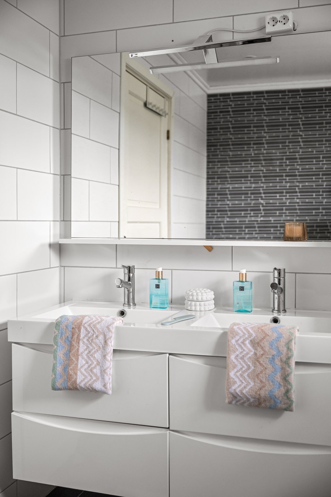 Badet er innredet med dobbel servant i seksjon, høyskap, frittstående badekar med dusjmulighet og toalett. Galleribilde