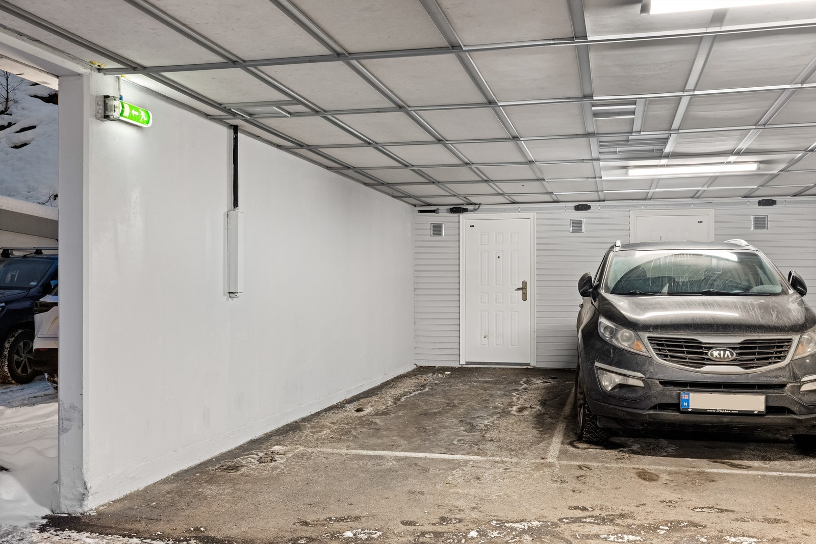 Medfølgende parkeringsplass med bod i bakkant. Galleribilde