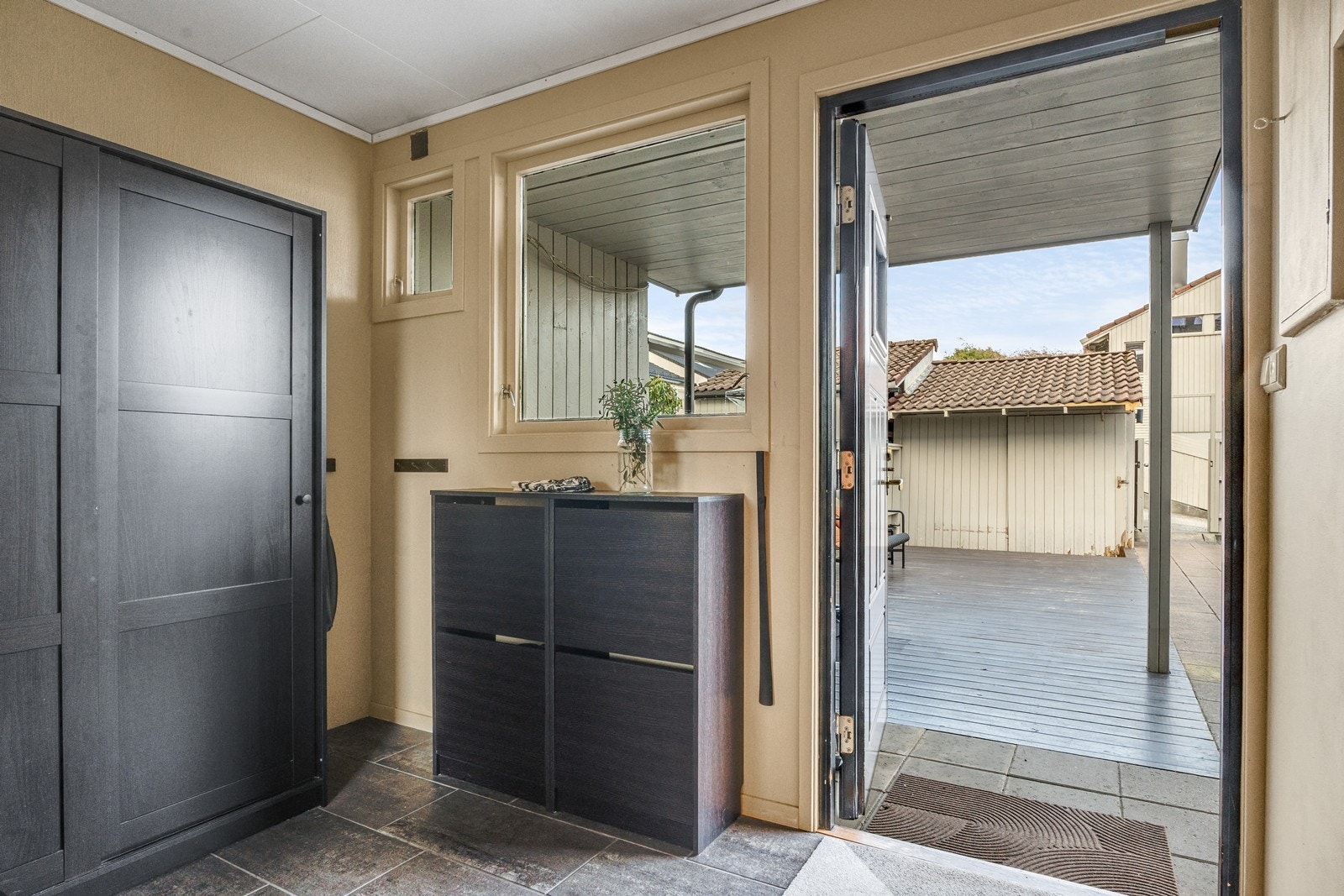 Lys og innbydende entré med fliser på gulv og god plass til oppheng og oppbevaring av yttertøy. Galleribilde