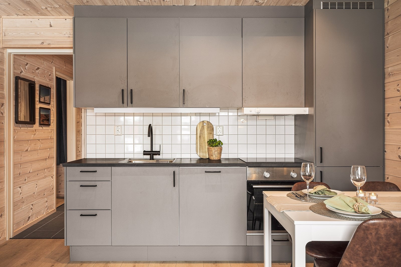 Kjøkkenet har innredning med slette fronter, laminert benkeplate, stålvask og integrerte hvitevarer Galleribilde