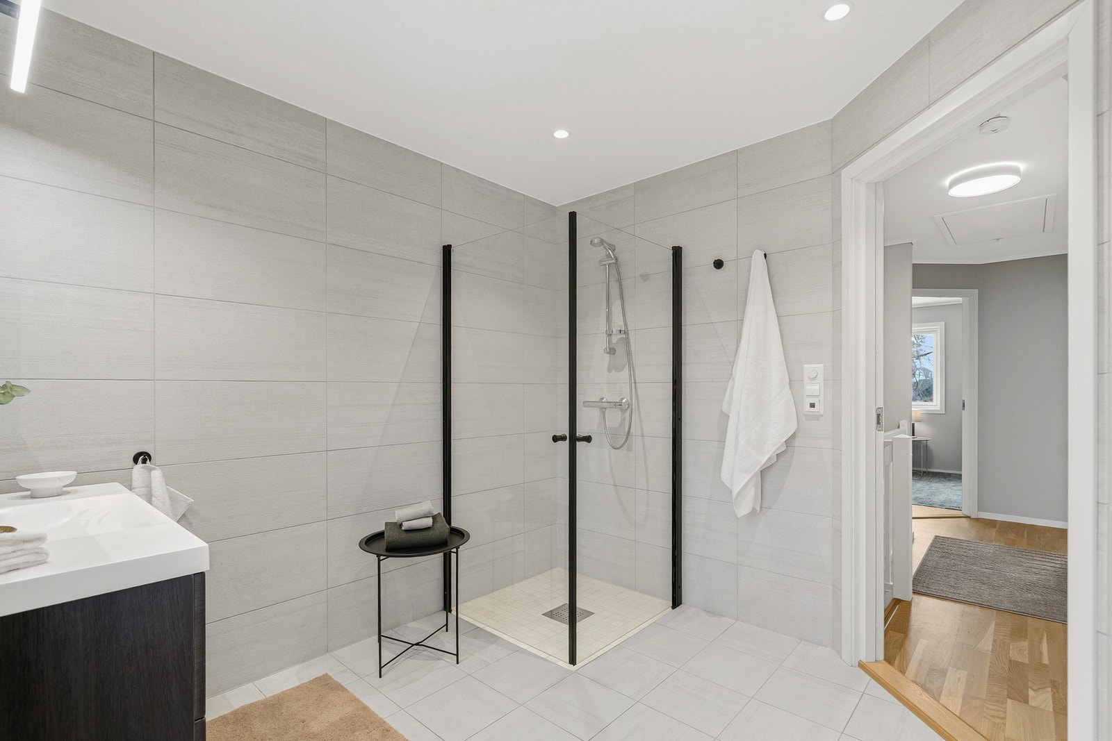 Badet er flislagt på gulv og vegger med smakfulle og stilrene fliser Galleribilde