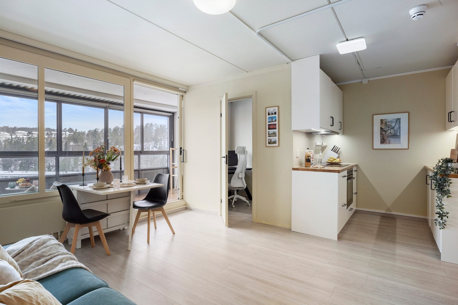 Rommet har store vindusflater som slipper inn rikelig med dagslys, laminat fra 2021 i en tidløs nyanse og nøytrale vegger som skaper en lun og innbydende atmosfære. Galleribilde