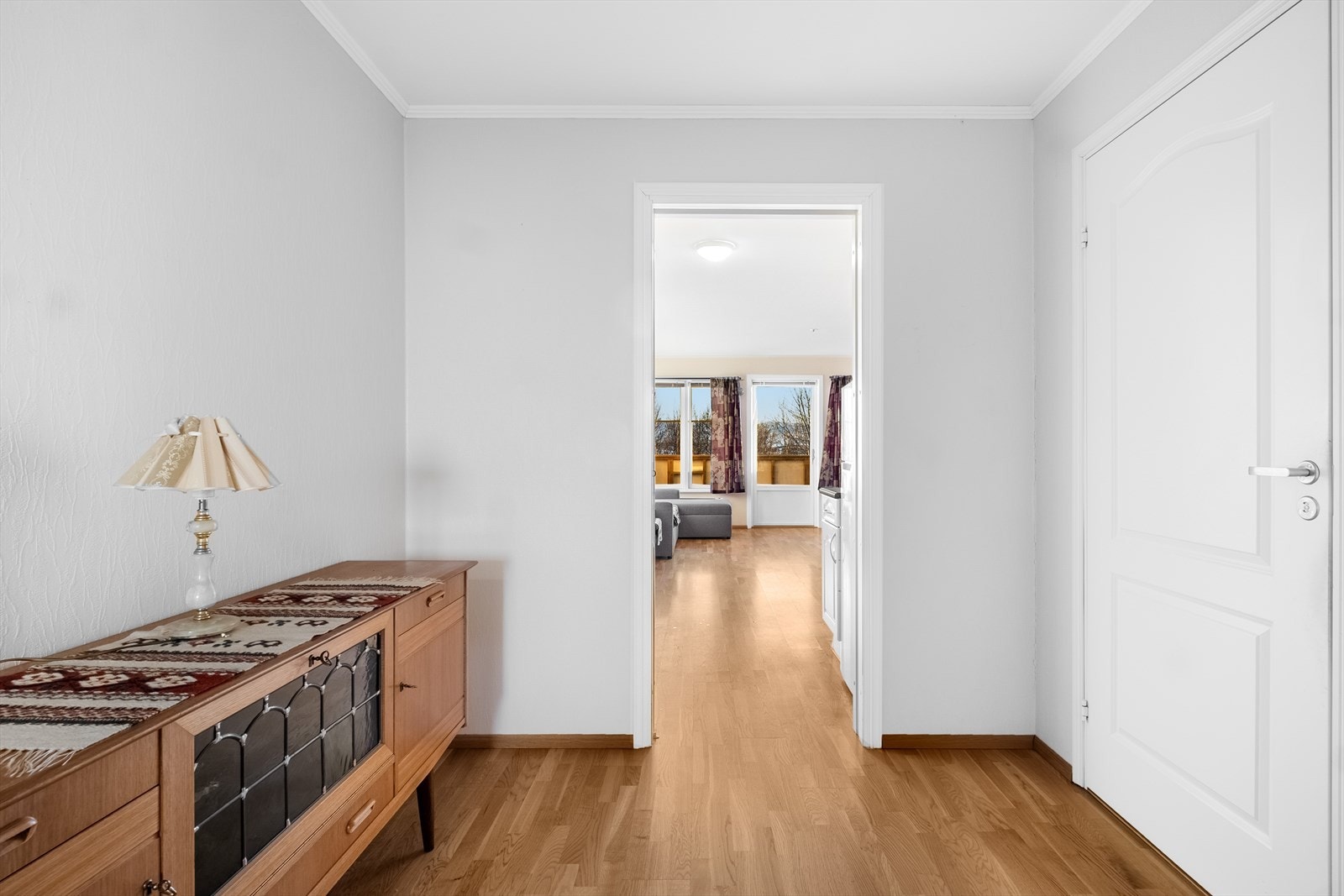 Videre inn i boligen kommer du til selve hjertet av leiligheten, hvor stue og kjøkken ligger i en åpen løsning. Galleribilde