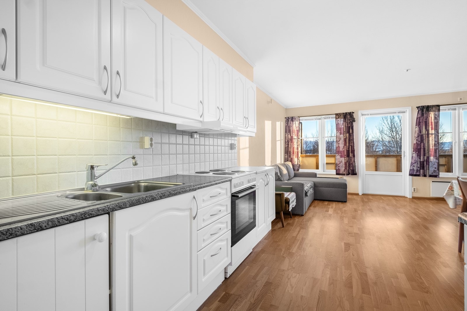 Kjøkkenet, som er fra byggeåret, har en tidløs innredning med profilerte fronter og byr på god skap- og benkeplass som gjør matlagingen både praktisk og oversiktlig. Galleribilde