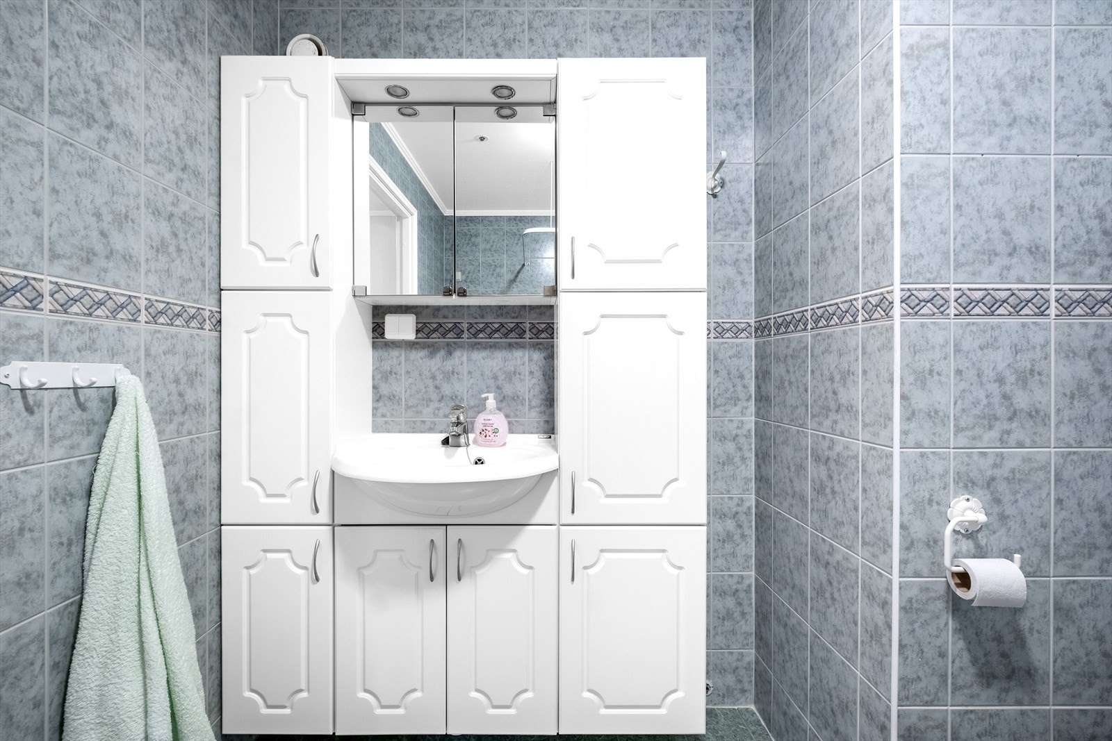 Baderommet er innredet med en romslig baderomsinnredning med nedfelt servant. Her får du god oppbevaringsplass, noe som gjør det enkelt å holde rommet ryddig og organisert i hverdagen. Galleribilde