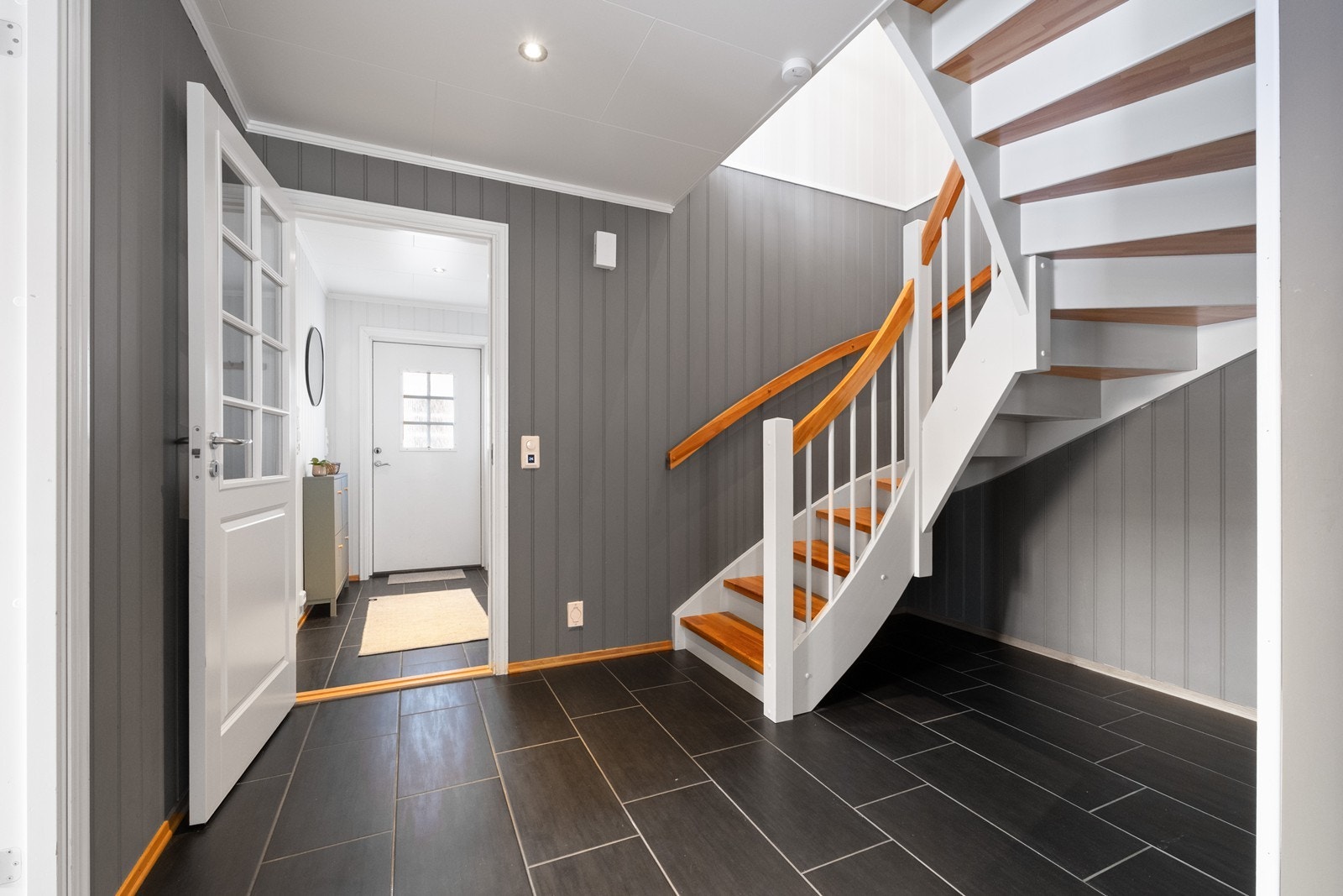 Flislagt gulv i entréen gir en robust og lettstelt overflate, mens trappen i tre gir en elegant forbindelse mellom etasjene. Galleribilde