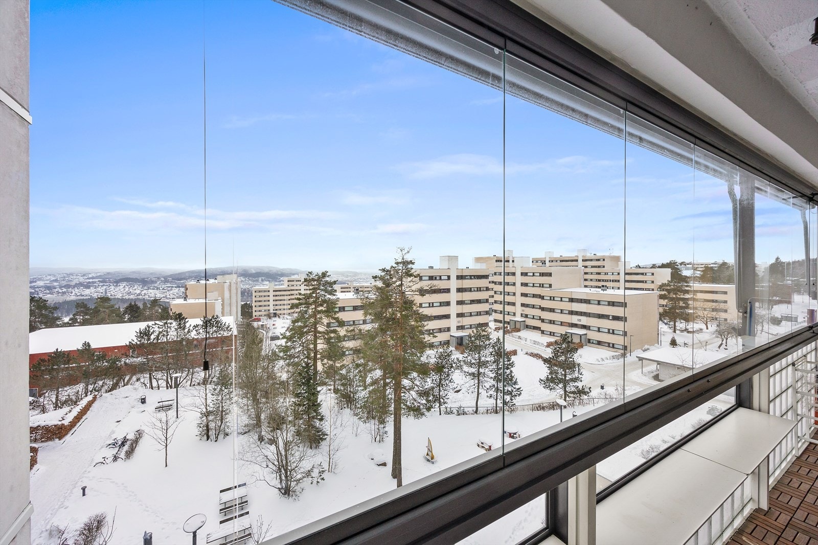 Utsikten fra den innglassede balkongen er mot borettslagets fellesarealer. Galleribilde