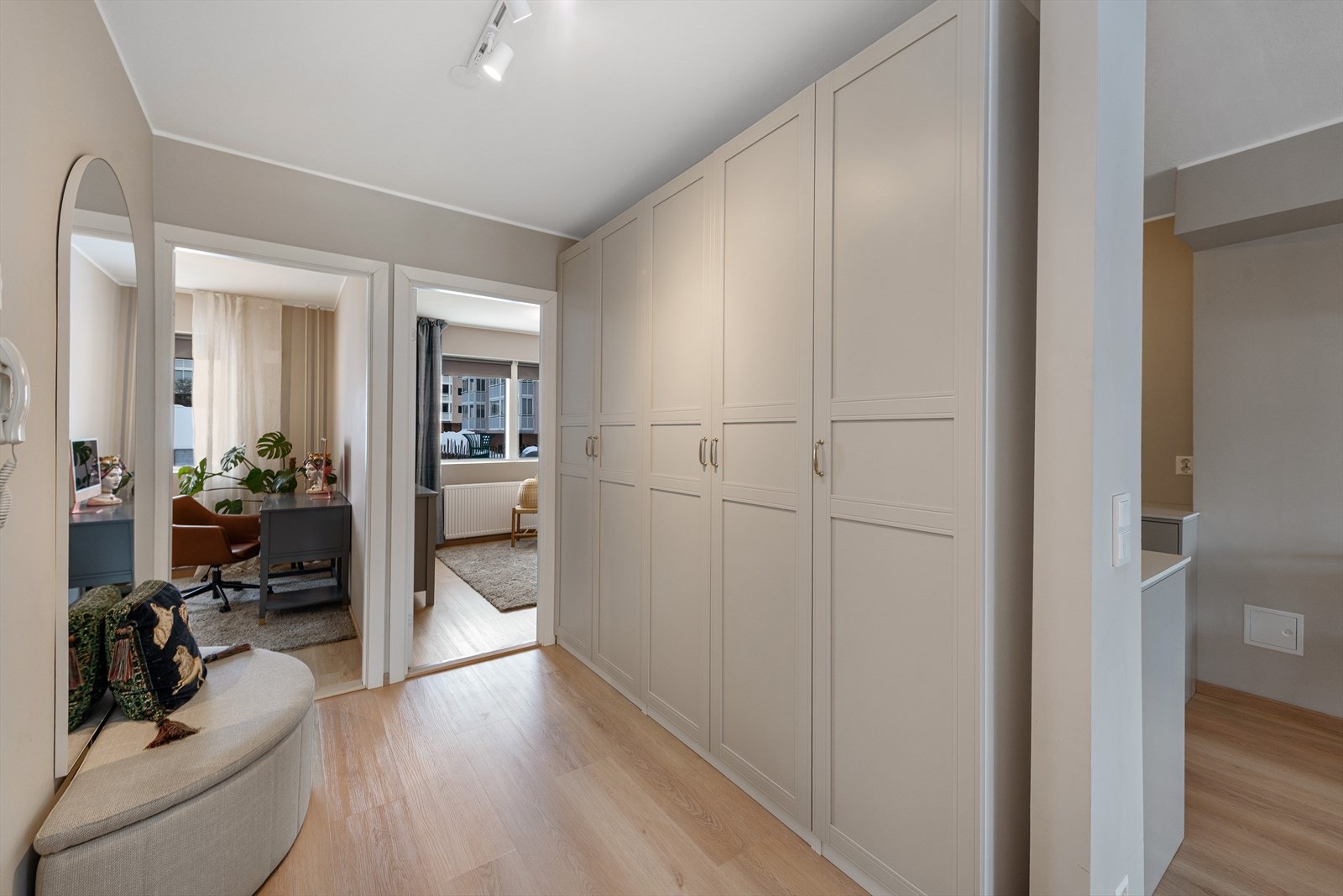 Velkommen inn! Romslig entré/gang med stor og påkostet garderobeinnredning som følger stilen til resten av leiligheten Galleribilde