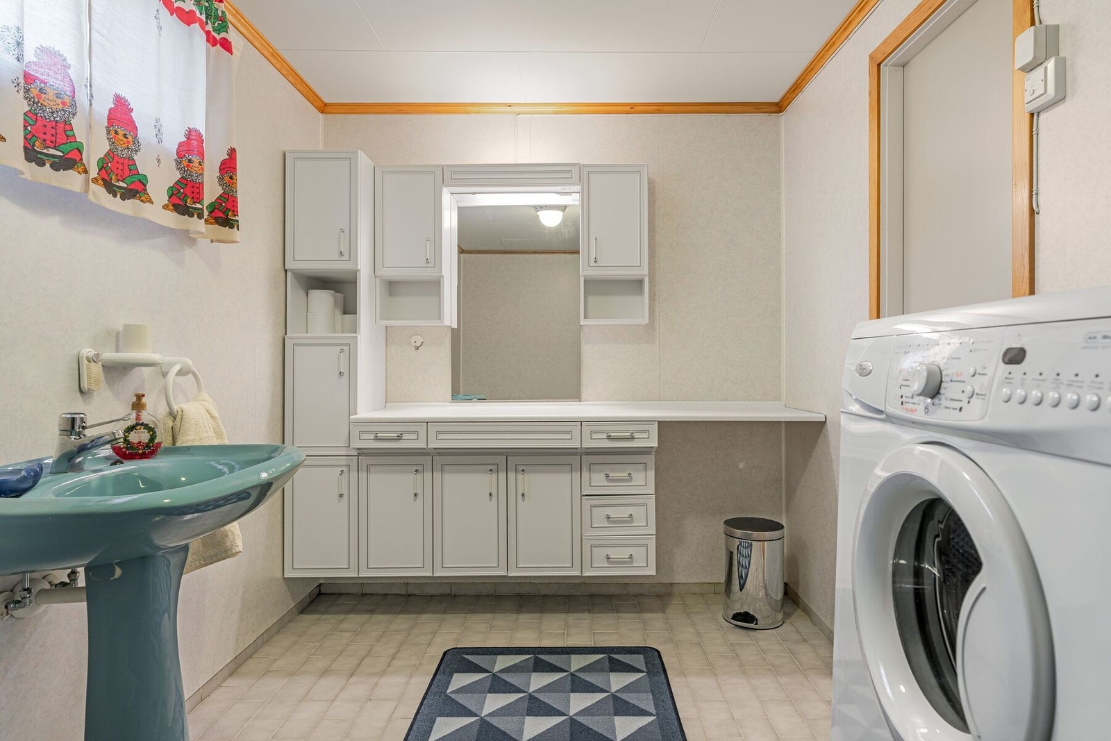 Badet i underetasjen er utstyrt med servant i innredning, toalett, badekar og opplegg for vaskemaskin Galleribilde