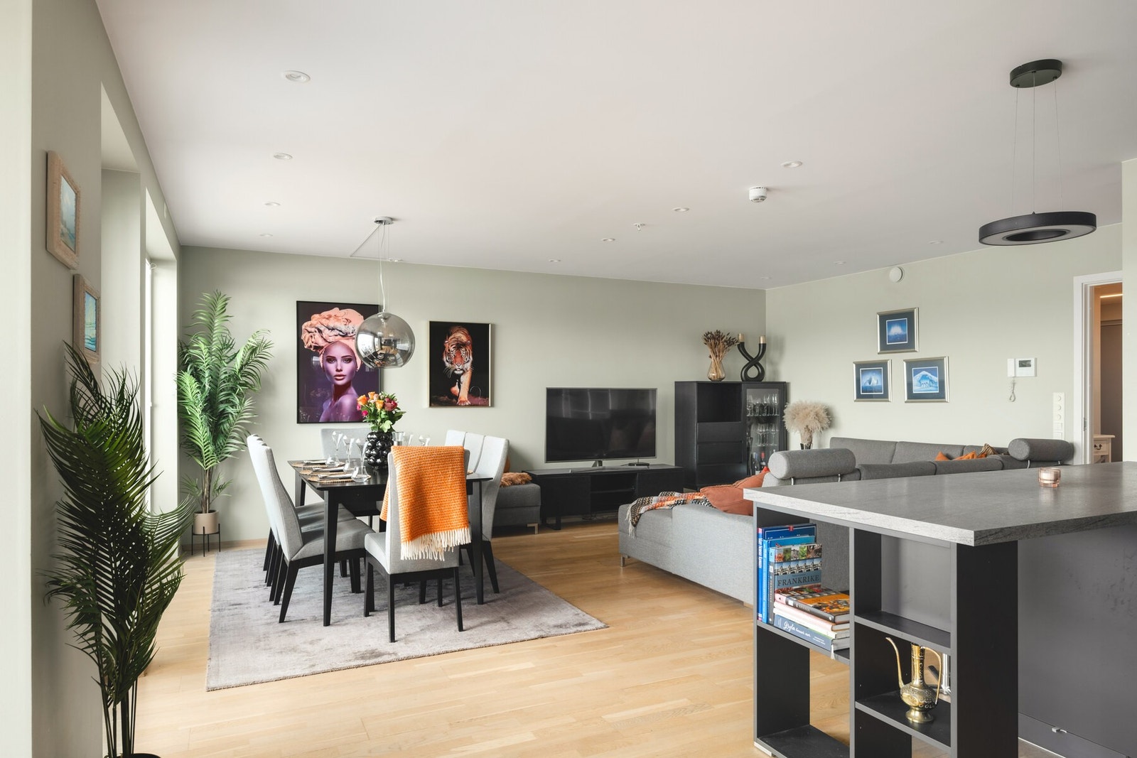 Romslig stue med lysinnslipp fra flere vinduer og åpen løsning mot kjøkkenet. Galleribilde