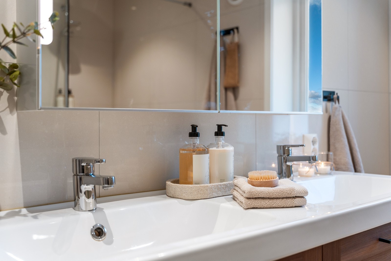 Det er innredet med dobbel servant i møblement, speilskap m/belysning, romslig dusj med skillevegg i glass og vegghengt toalett. Galleribilde