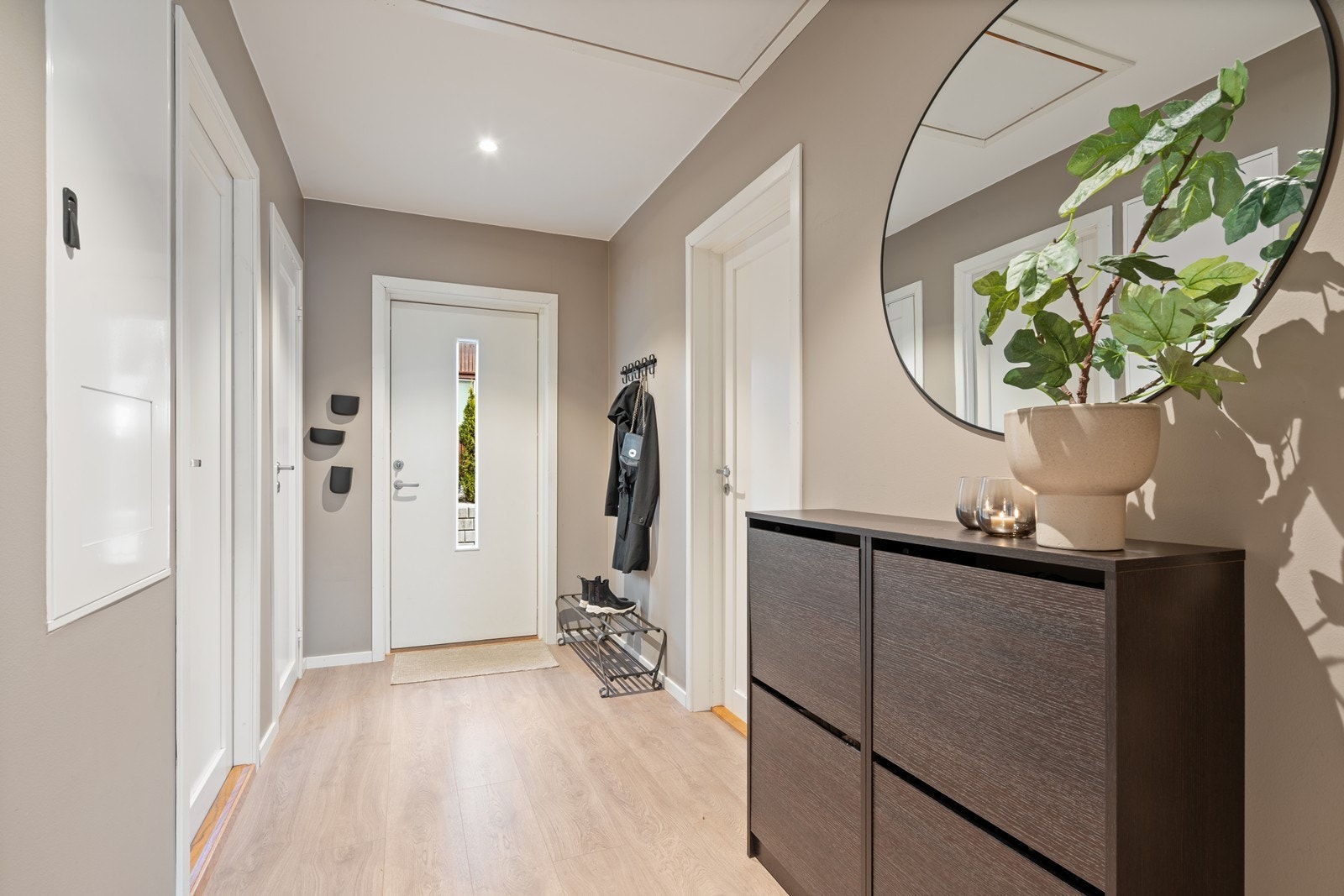 Romslig entrè med god plass til oppbevaring av yttertøy og sko i ønsket oppbevaringsmøblement. Galleribilde