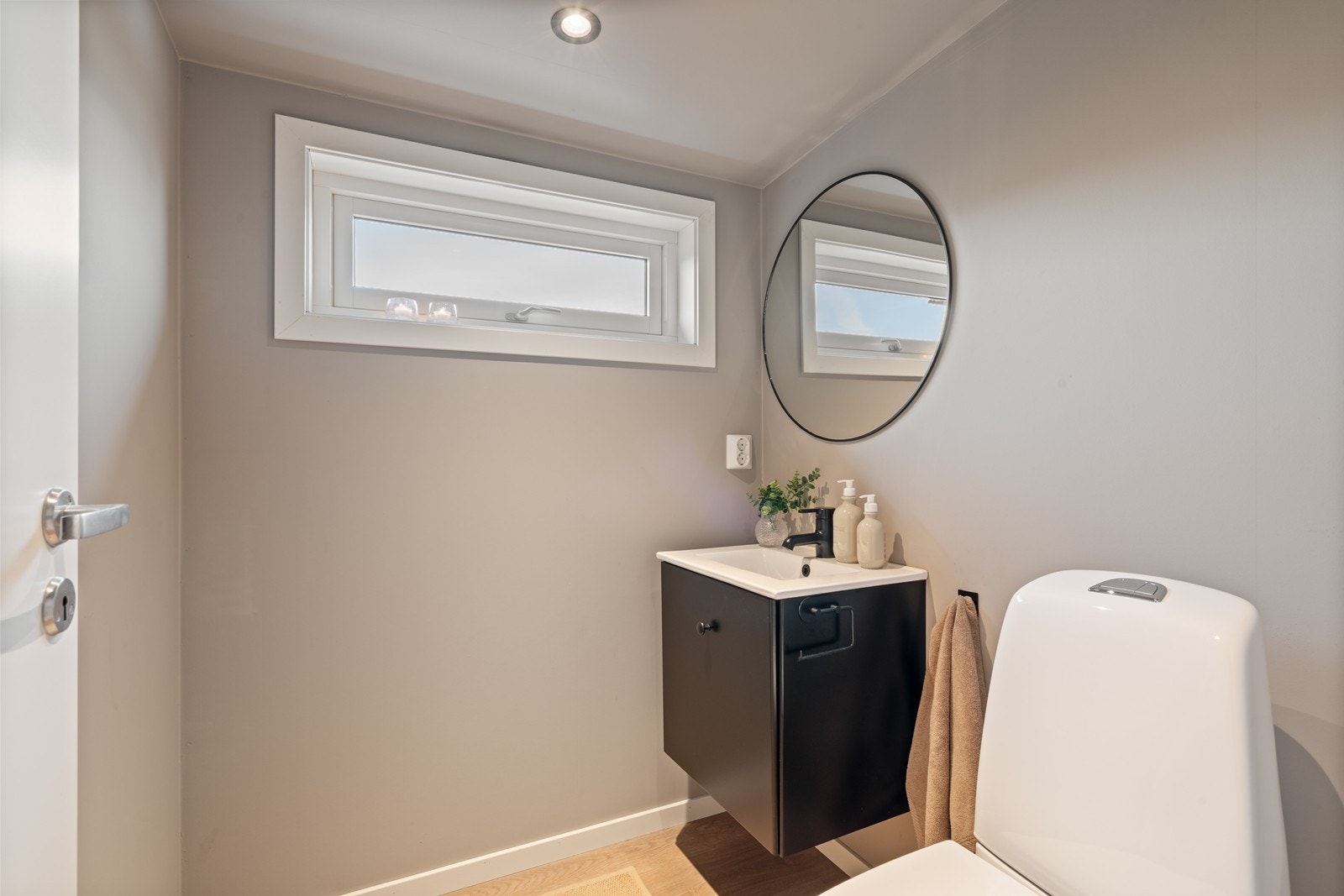 Toalettrommet har servant i møblement, speil og toalett. Galleribilde